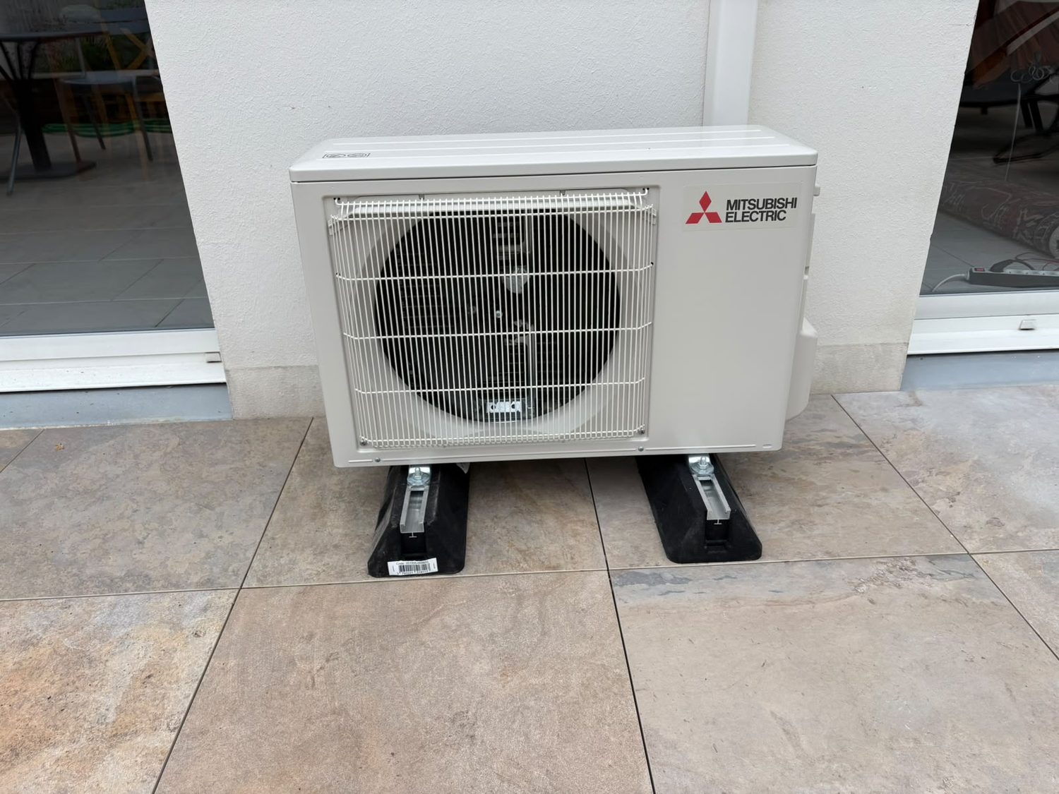 Groupe extérieur de climatisation posé sur plots en terrasse